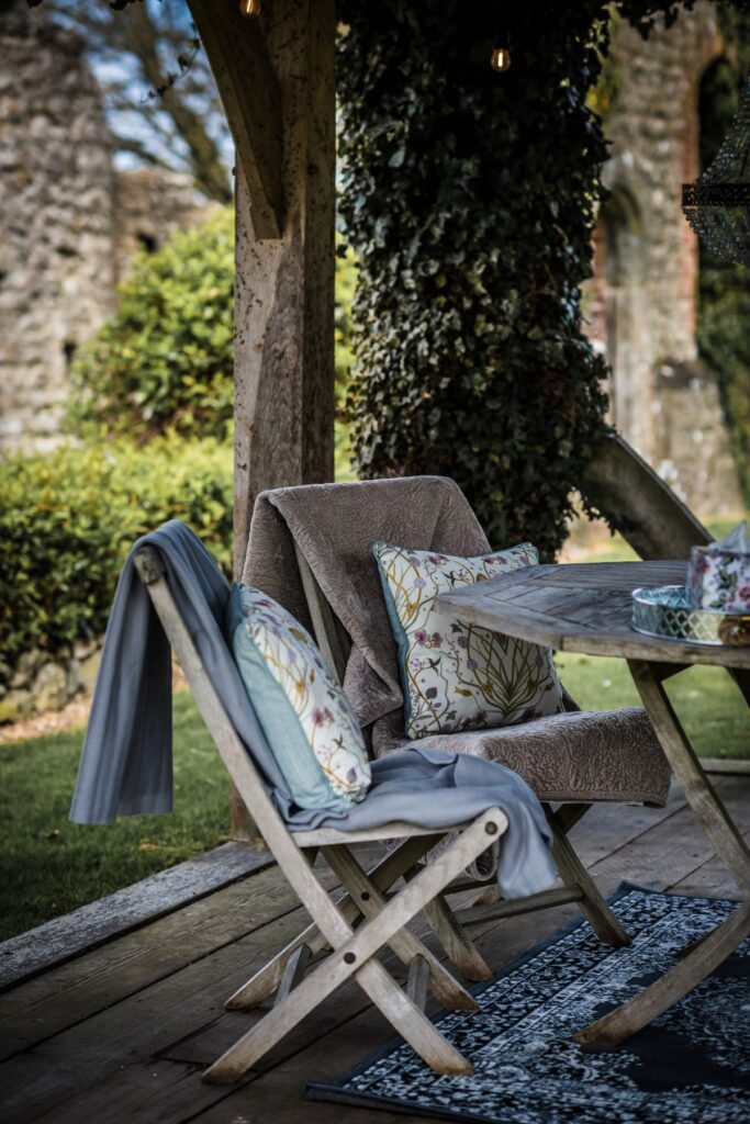 Two wooden deck chairs with blankets