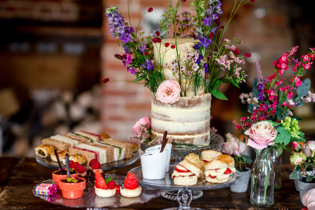 Butter icing wedding cake covered in wildflowers with an afternoon tea wedding breakfast