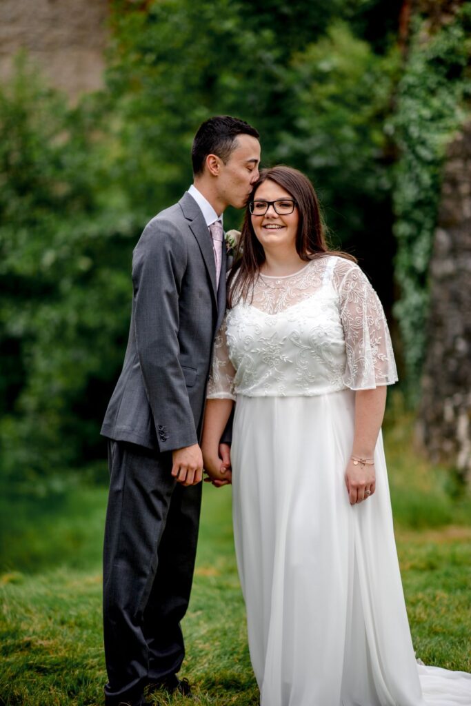 Groom kisses his bride on her head after their elopement at the Castle Westenhanger, Kent