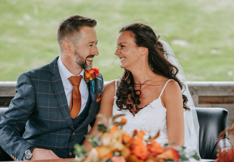 A couple look at each other in the gazebo at The Cave after saying I do in front of their family