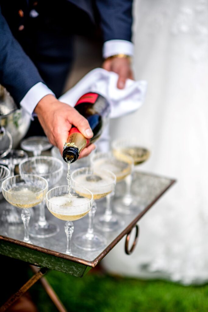 Kirsty and Steve's real elopement at the Castle Westenhanger in Kent by team E-Lope. Steve pours champagne for their petite wedding party reception