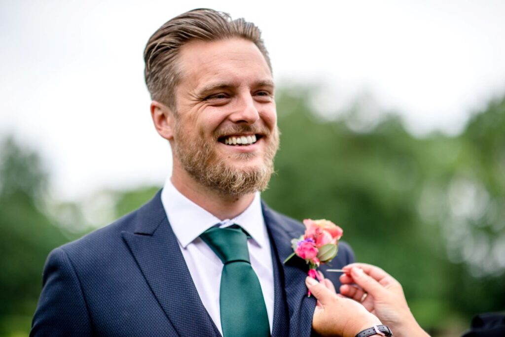 Kirsty and Steve's real elopement at the Castle Westenhanger in Kent by team E-Lope. Sam, The Wedding Owl adds Steve's buttonhole to his blue suit