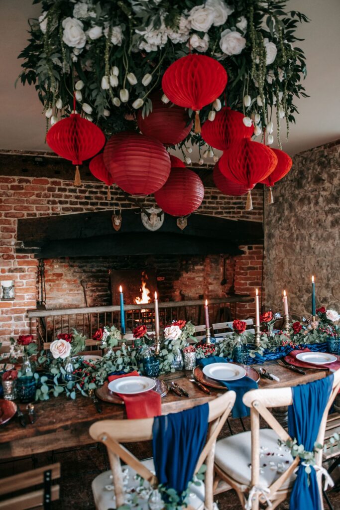A December elopement at the Castle Westenhanger Kent England is decorated with red paper pompoms