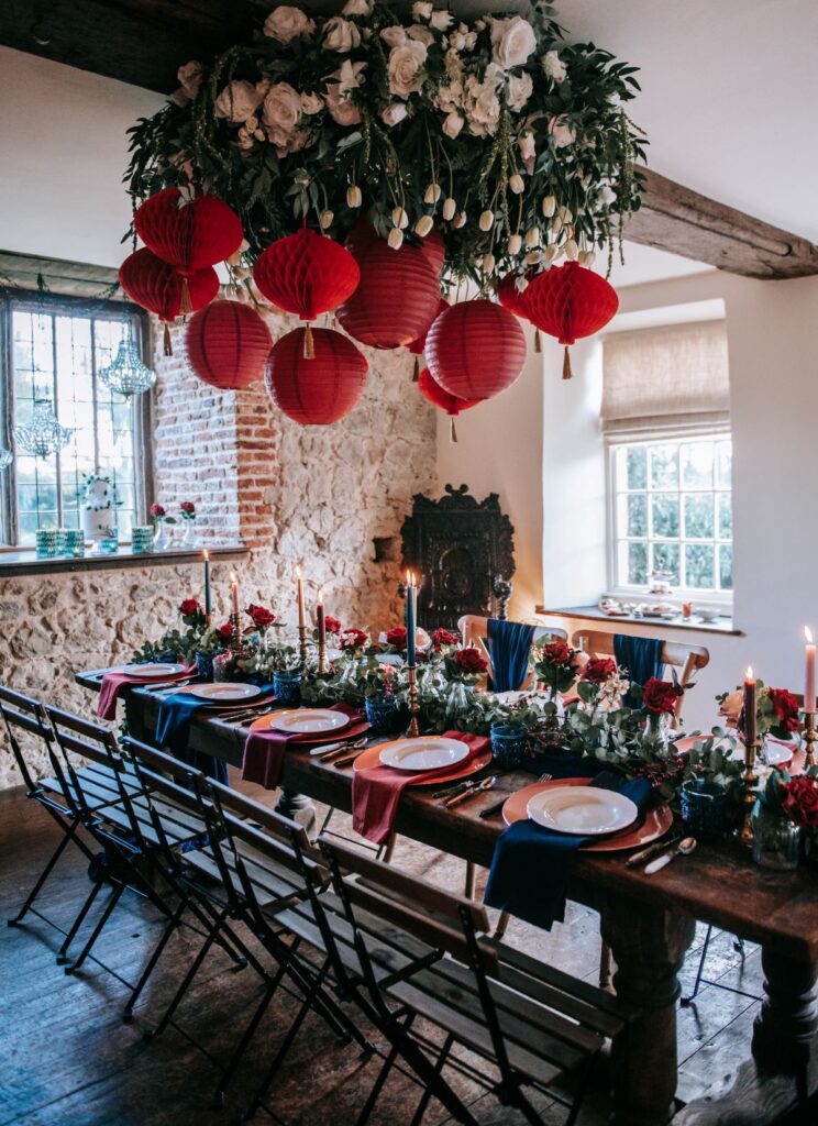 A December elopement at the Castle Westenhanger Kent England is decorated with red paper pompoms
