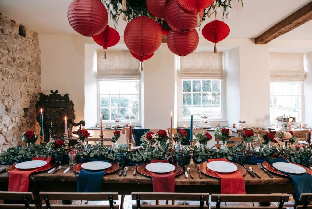 A December elopement at the Castle Westenhanger Kent England is decorated with red paper pompoms