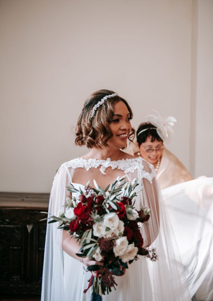 Kate's mum helps her straighten her bridal cap and dress before her tiny wedding at the Castle Westenhanger Kent England