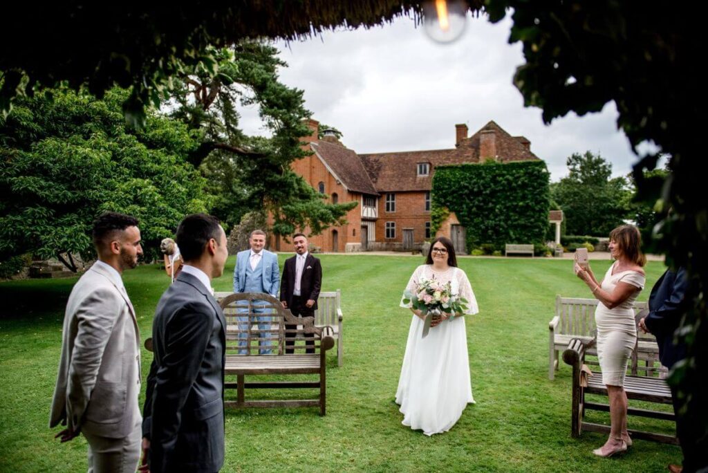 The bride walks down the aisle at the Castle Westenhanger in Kent England