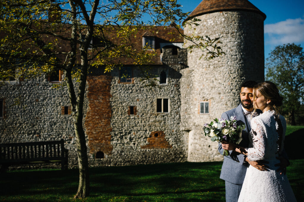 The couple enjoy moments with their elopement photographer outside the Castle Westenhanger in Kent England