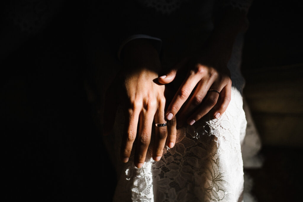 The bride and groom check out each others wedding rings after eloping at the Castle Westenhanger in Kent, England