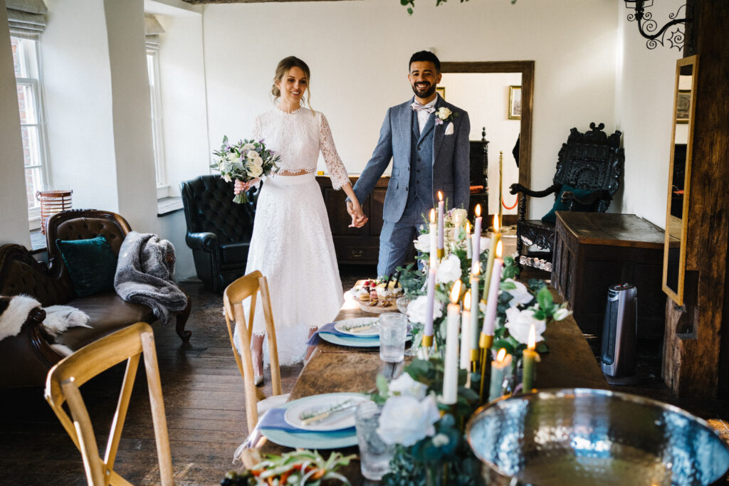 The couple enter the room after their ceremony in the Dovecote for an intimate elopement wedding breakfast of afternoon tea for two at The Castle Westenhanger Kent England