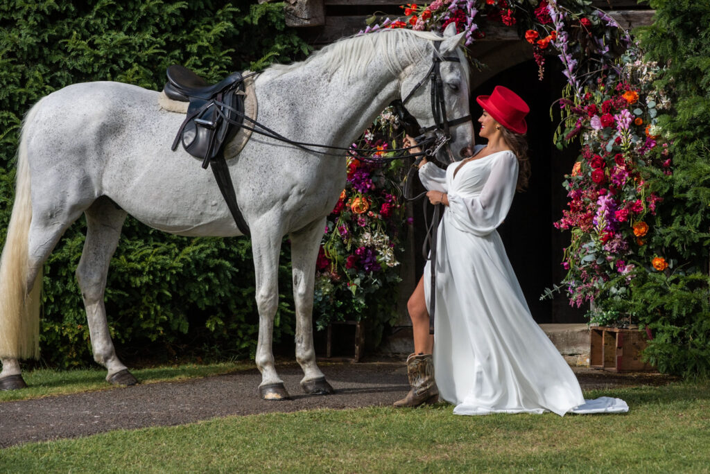 A bride arrives at the front of Bilsington Priory on a horse
