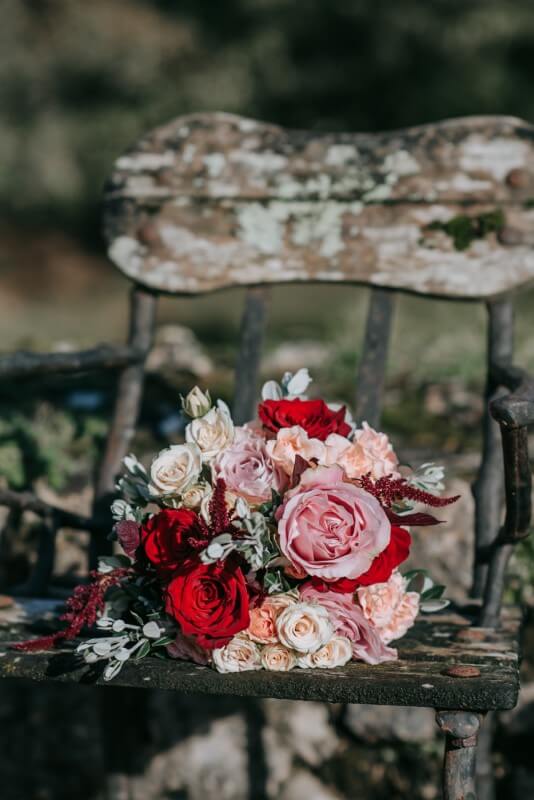 A pink elopement package bouquet on a bench at the Castle Westenhanger