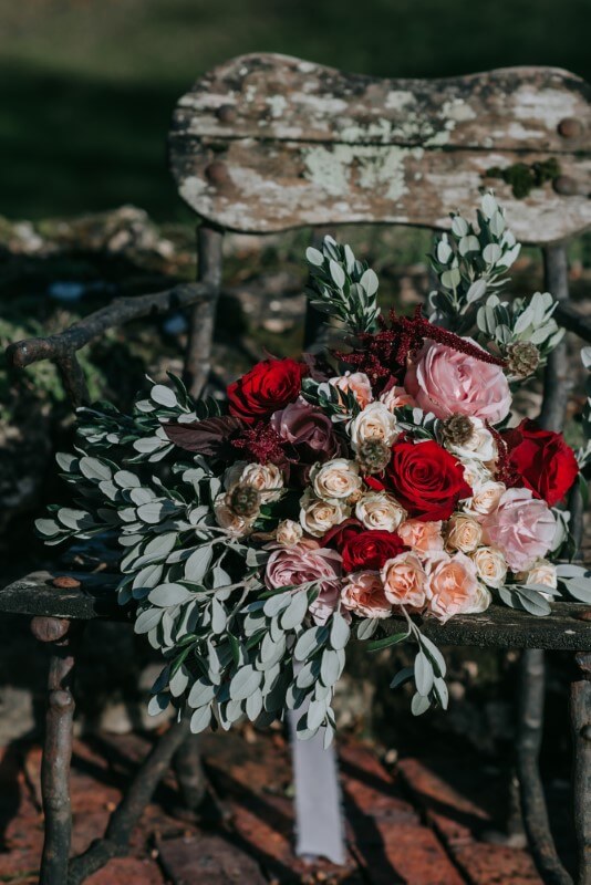 A stunning bouquet that includes roses and eucalptus flows out over a chair at the castle westenhanger
