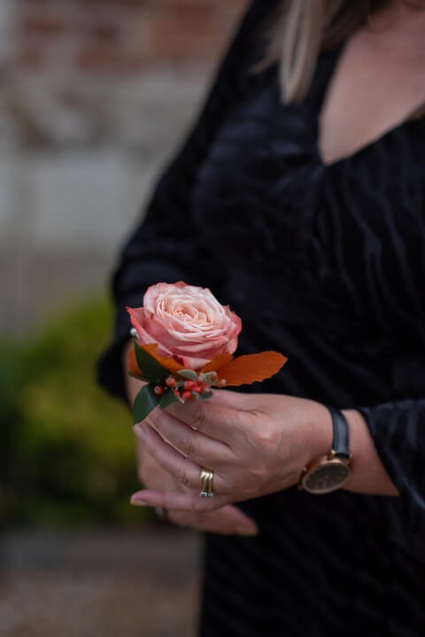 Sam the Wedding Owl holds an autumn buttonhole created by House of Mimi Fleur for an elopement at the Castle Westenhanger, Kent, England