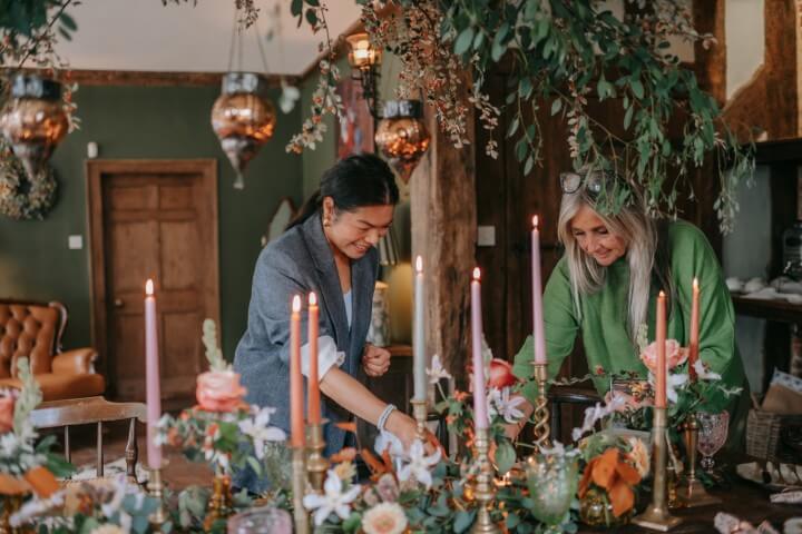 Serena of Cobi and Coco and Ruth of House of Mimi Fleur adding the final touches to an autumn elopement during an autumn elopement at The Castle Westenhanger